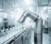 An automated food and beverage packaging line utilizing a sealed, stainless steel rotary actuator for wash-down processing.
